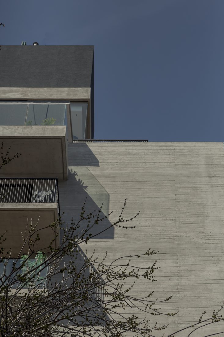 Volumen superior del edificio en hormigón visto contra el cielo